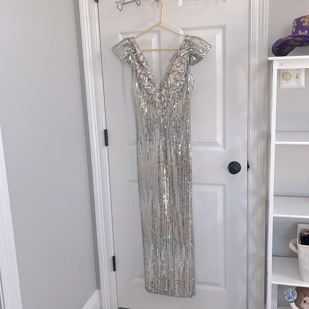 Silver sequins gown fitted with back slit.